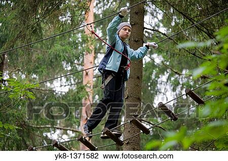 Stock Image - Teenage boy on exercise trail in adventure park trail, Otep??, Estonia. Fotosearch