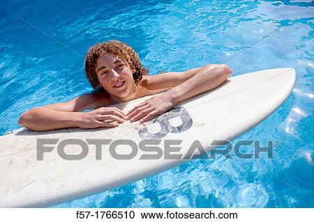 Teenage boy on his surfboard View Large Photo Image Stock Image - Teenage boy on his surfboard. Fotosearch