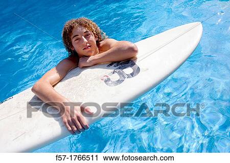 Teenage boy on his surfboard View Large Photo Image Stock Image - Teenage boy on his surfboard. Fotosearch