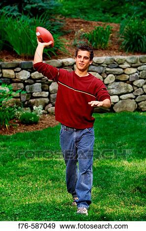 Teenage boy passing or throwing a football. View Large Photo Image Stock Photo - Teenage boy passing or throwing a football.. Fotosearch