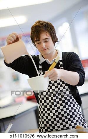 Teenage boy pouring milk into a bowl in food science cookery class, secondary school UK View Large Photo Image Stock Photograph - Teenage boy pouring milk into a bowl in food science cookery class, secondary school UK. Fotosearch
