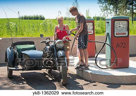 Stock Photo - Teenage Boy Refilling Old Sidecar Motorcycle in Gas Station, Estonian Road Museum, Estonia. Fotosearch