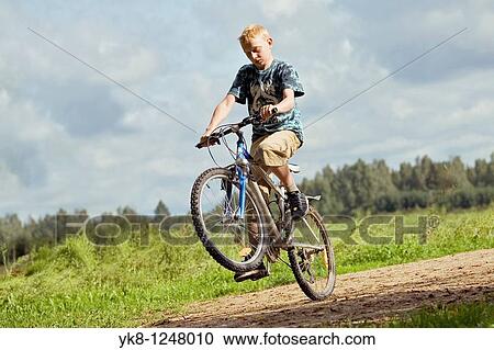Teenage Boy Riding Bicycle and Doing Action Trick View Large Photo Image Stock Image - Teenage Boy Riding Bicycle and Doing Action Trick. Fotosearch