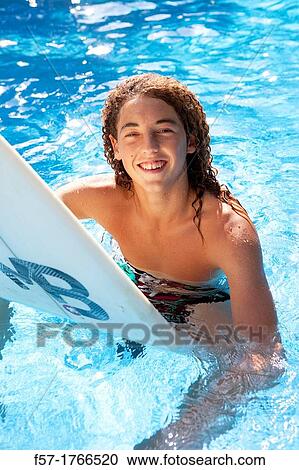 Teenage boy sitting on his surfboard View Large Photo Image Stock Image - Teenage boy sitting on his surfboard. Fotosearch