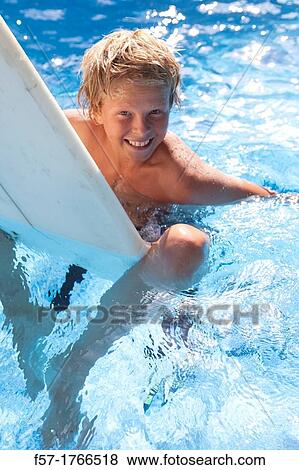 Teenage boy sitting on his surfboard View Large Photo Image Stock Photo - Teenage boy sitting on his surfboard. Fotosearch