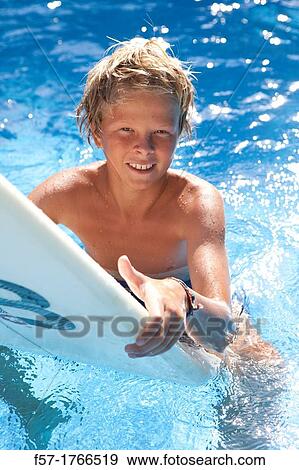 Teenage boy sitting on his surfboard View Large Photo Image Stock Photo - Teenage boy sitting on his surfboard. Fotosearch