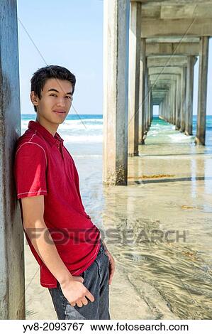 Stock Photo - Teenage boy standing by Scripps pier, La Jolla, California.. Fotosearch
