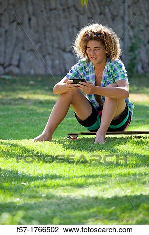 Stock Image - Teenage boy using his smart phone. Fotosearch