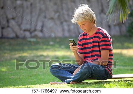 Teenage boy using his smart phone View Large Photo Image Stock Photo - Teenage boy using his smart phone. Fotosearch