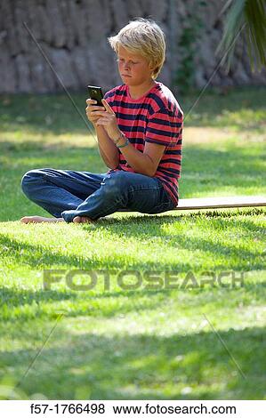 Teenage boy using his smart phone View Large Photo Image Stock Photo - Teenage boy using his smart phone. Fotosearch