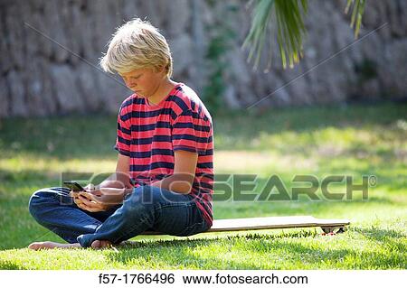 Teenage boy using his smart phone View Large Photo Image Stock Photograph - Teenage boy using his smart phone. Fotosearch