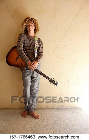 Stock Image - Teenage boy with his guitar. Fotosearch