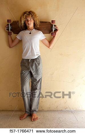 Stock Image - Teenage boy with his longboard. Fotosearch