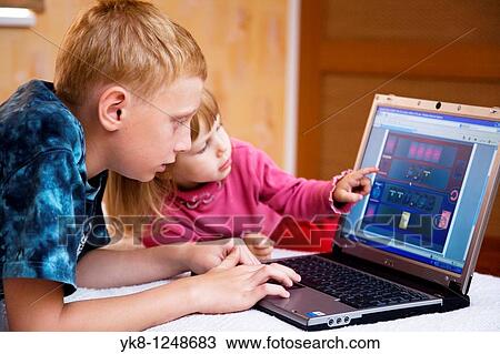 Teenage Boy with Kid Girl Lying Down and Using Laptop Computer View Large Photo Image Stock Image - Teenage Boy with Kid Girl Lying Down and Using Laptop Computer. Fotosearch