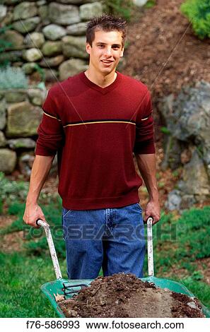 Teenage boy working in garden, with wheel barrow. View Large Photo Image Stock Image - Teenage boy working in garden, with wheel barrow.. Fotosearch