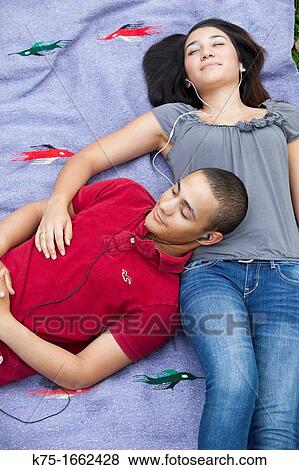 Teenage couple enjoying music together View Large Photo Image Stock Photo - Teenage couple enjoying music together. Fotosearch