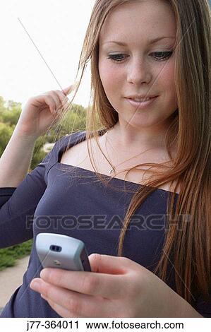 Stock Image - Teenage female with cell phone. Fotosearch