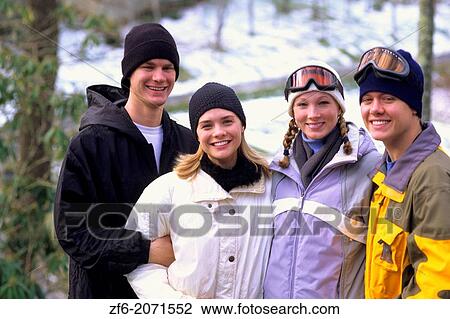 Stock Image - Teenage friends enjoying each others company on the ski slopes.. Fotosearch
