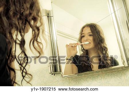 Stock Photography - Teenage girl brushing her teeth. Fotosearch