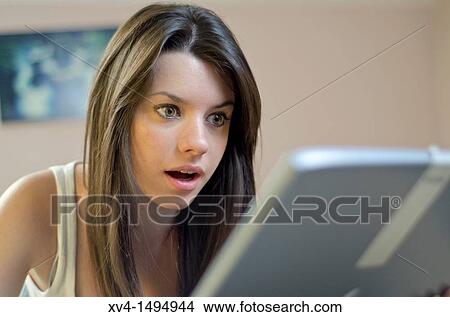 Picture - Teenage girl chatting with notebook in her home. Fotosearch