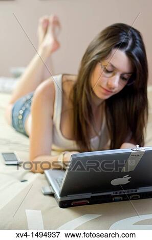 Stock Photo - Teenage girl chatting with notebook in her home. Fotosearch