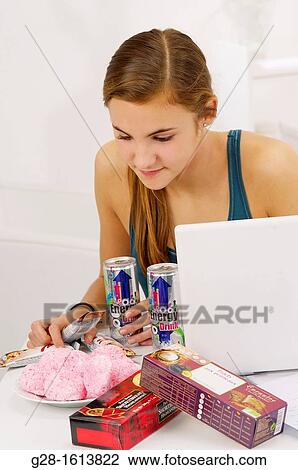 Teenage girl doing her homework and using her computer, while eating sweets, cookies, and drinking energy drinks View Large Photo Image Stock Image - Teenage girl doing her homework and using her computer, while eating sweets, cookies, and drinking energy drinks. Fotosearch