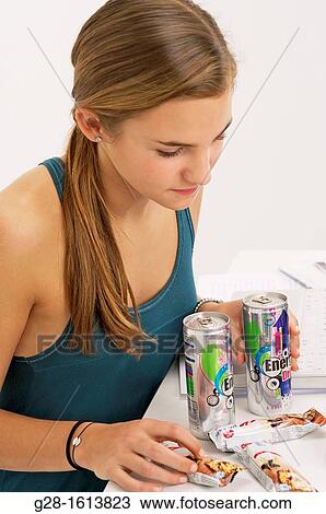 Teenage girl doing her homework and using her computer, while eating sweets, cookies, and drinking energy drinks View Large Photo Image Stock Image - Teenage girl doing her homework and using her computer, while eating sweets, cookies, and drinking energy drinks. Fotosearch