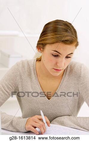Teenage girl doing her homework at home View Large Photo Image Picture - Teenage girl doing her homework at home. Fotosearch