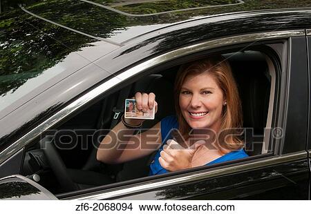 Teenage girl happy to be driving and finally getting her drivers license in first car giving thumbs up sign. View Large Photo Image Picture - Teenage girl happy to be driving and finally getting her drivers license in first car giving thumbs up sign.. Fotosearch