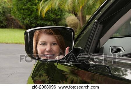 Teenage girl happy to be driving and finally getting her drivers license in first car giving thumbs up sign looking in side mirror. View Large Photo Image Stock Photograph - Teenage girl happy to be driving and finally getting her drivers license in first car giving thumbs up sign looking in side mirror.. Fotosearch