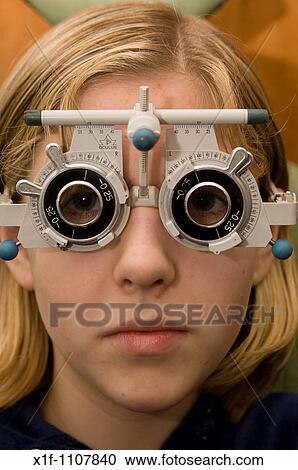 Teenage girl having her eyes tested by an optician View Large Photo Image Stock Image - Teenage girl having her eyes tested by an optician. Fotosearch