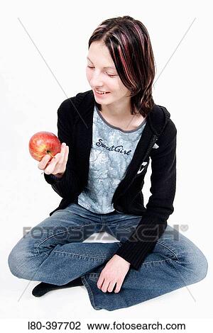 Teenage girl looking at an apple View Large Photo Image Stock Image - Teenage girl looking at an apple. Fotosearch
