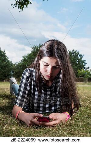 Stock Photo - Teenage girl looking at her phone.. Fotosearch