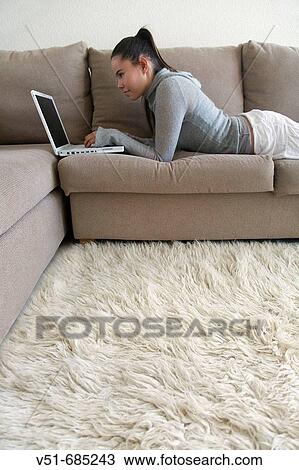 Teenage girl lying on couch with laptop View Large Photo Image Stock Image - Teenage girl lying on couch with laptop. Fotosearch
