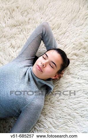 Teenage girl lying on the carpet daydreaming View Large Photo Image Stock Photo - Teenage girl lying on the carpet daydreaming. Fotosearch