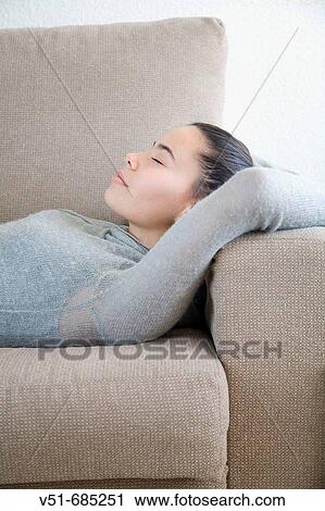 Stock Image - Teenage girl lying on the couch. Fotosearch