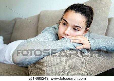 Teenage girl lying on the couch daydreaming View Large Photo Image Stock Photo - Teenage girl lying on the couch daydreaming. Fotosearch