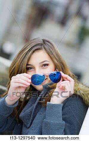 Teenage girl portrait happy with sunglasses in hand View Large Photo Image Stock Image - Teenage girl portrait happy with sunglasses in hand. Fotosearch