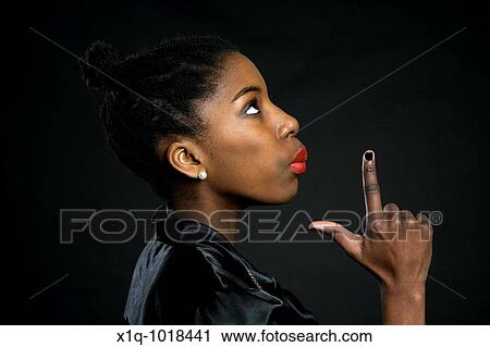 Stock Image - Teenage girl pretending to blow the smoke off a gun. Fotosearch