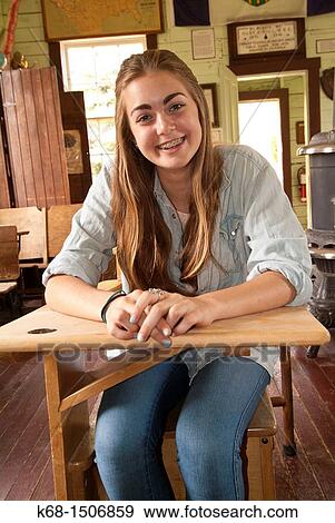 teenage girl sits in a desk in a museum school house at the Pincher Creek, Alberta, Canada museum View Large Photo Image Stock Photo - teenage girl sits in a desk in a museum school house at the Pincher Creek, Alberta, Canada museum. Fotosearch