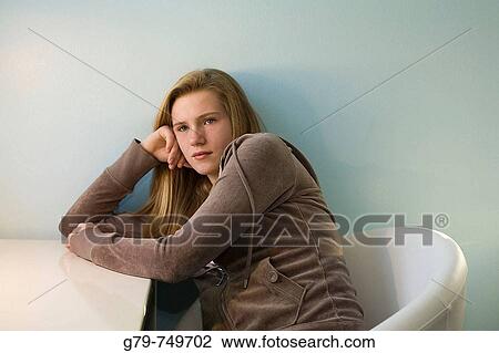 Teenage girl sitting at a desk. View Large Photo Image Stock Image - Teenage girl sitting at a desk.. Fotosearch