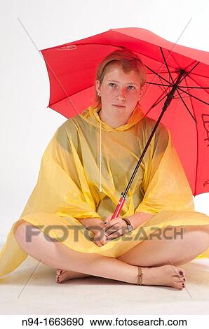Teenage girl sitting on the floor with yellow rain gear protected with red umbrella. View Large Photo Image Stock Image - Teenage girl sitting on the floor with yellow rain gear protected with red umbrella.. Fotosearch