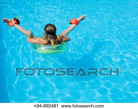 Teenage girl swimming in the pool with floats. View Large Photo Image Stock Image - Teenage girl swimming in the pool with floats.. Fotosearch