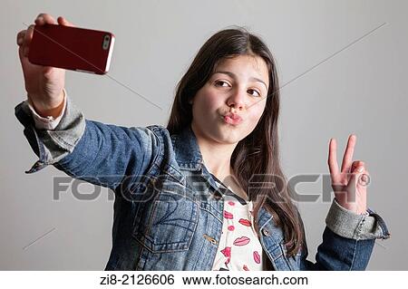 Stock Photograph - Teenage girl takes a selfie on camera phone.. Fotosearch
