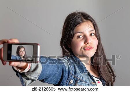 Stock Photography - Teenage girl takes a selfie on camera phone.. Fotosearch