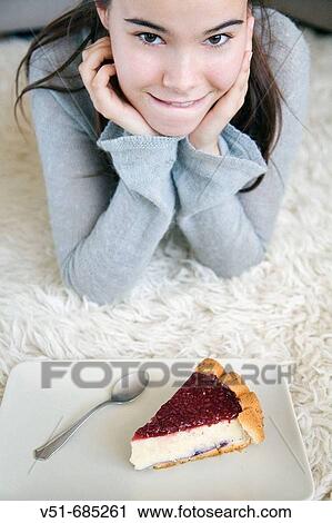 Stock Image - Teenage girl wanting to eat a cake at home. Fotosearch