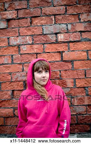 Teenage girl wearing a pink hoodie hooded top in front of a brick wall, UK View Large Photo Image Stock Image - Teenage girl wearing a pink hoodie hooded top in front of a brick wall, UK. Fotosearch