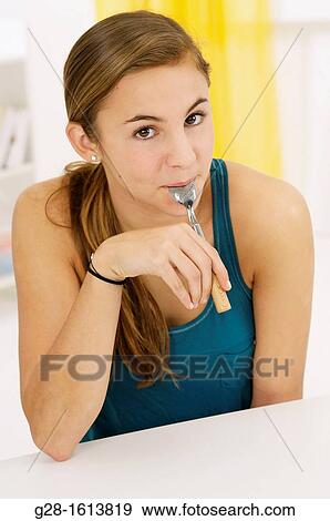 Teenage girl with a teaspoon in her mouth View Large Photo Image Stock Photo - Teenage girl with a teaspoon in her mouth. Fotosearch