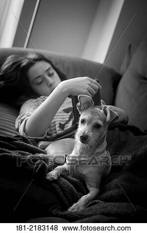 Teenage girl with her dog on the couch at home. Peniscola, Castell? n, Valencia, Spain. View Large Photo Image Stock Photo - Teenage girl with her dog on the couch at home. Peniscola, Castell? n, Valencia, Spain.. Fotosearch
