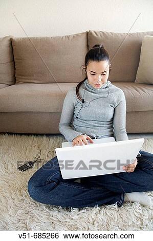 Teenage girl with laptop and listening music at home View Large Photo Image Stock Photograph - Teenage girl with laptop and listening music at home. Fotosearch